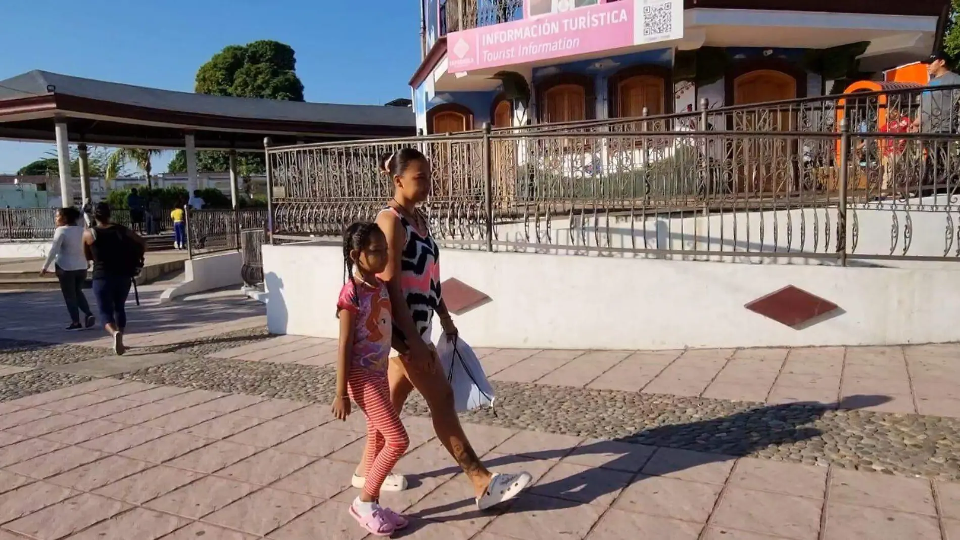 migrante caminando en el parque con su hija 